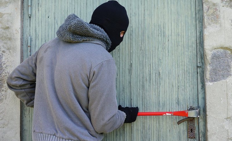 stock image of thief breaking into property
